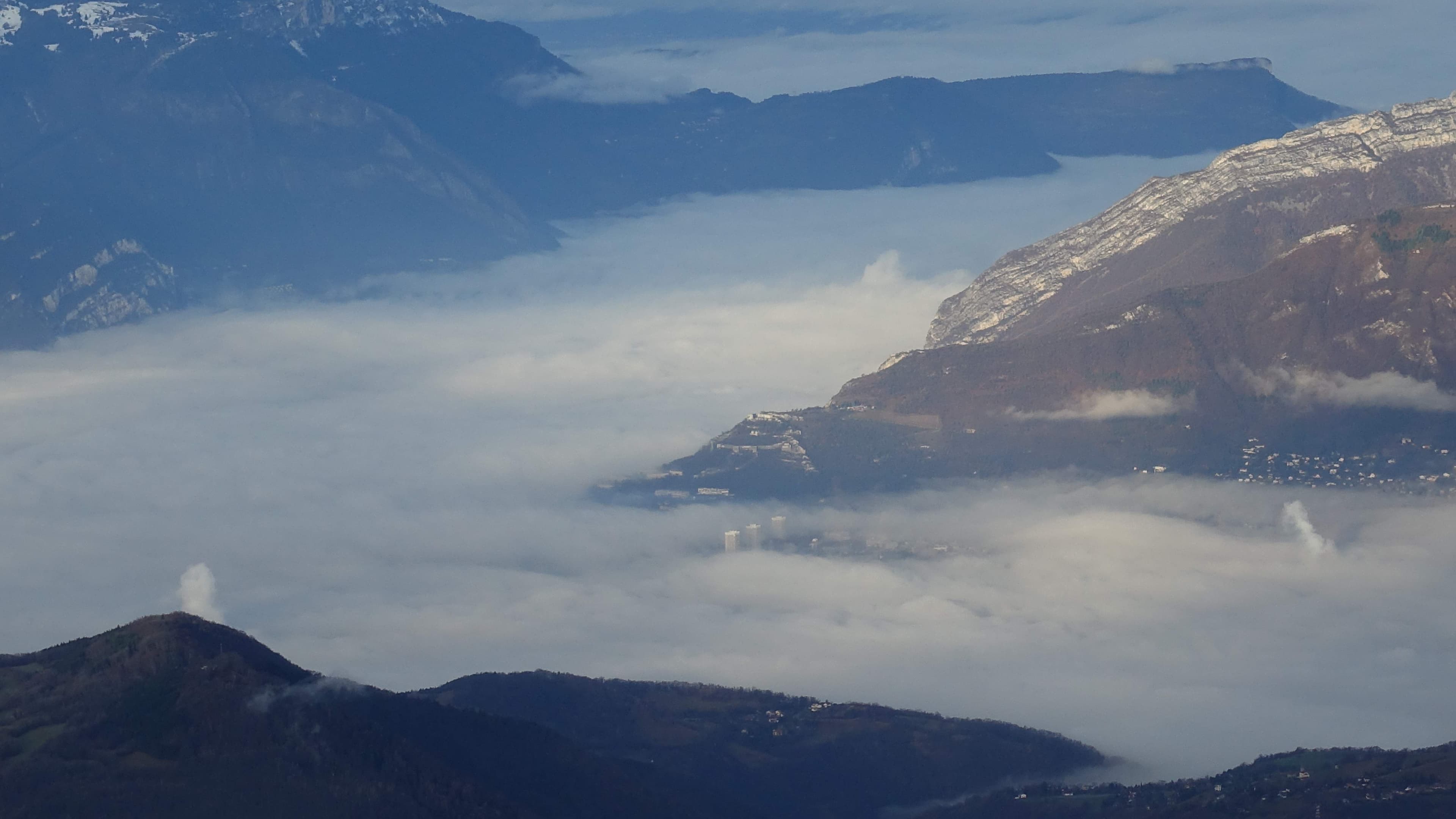 Grenoble dans le brouillard on distingue la Bastille et les 3 tours A.P.